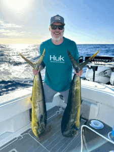 man holding two big fish sporting fish honolulu hi