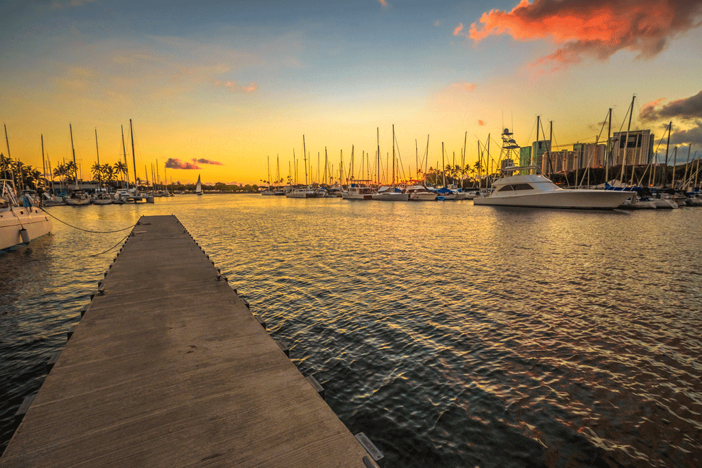 multiple different boats in the ocean during sunset private boat charters oahu hi honalulu hi