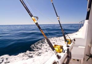 Two big fishing reels on a boat in the ocean.